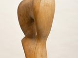 a wooden sculpture of two hands holding each other on top of a white pedestal