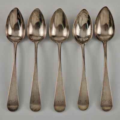 six cuillères sont alignées sur une table