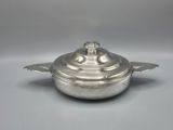 an antique silverplated casserole dish with a lid
