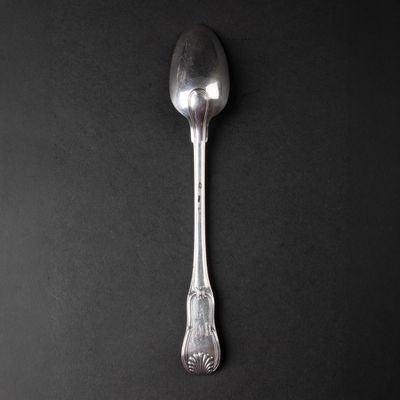 silver spoon on a black surface with a black background