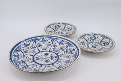 trois assiettes bleues et blanches à motifs sur une surface blanche