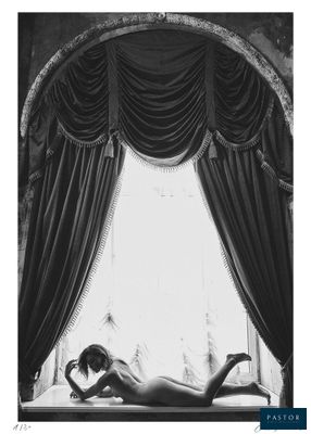 photographie en noir et blanc d'une femme allongée sur un lit devant une fenêtre