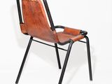 a brown leather chair with black legs and a black frame