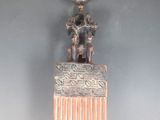 un peigne en argent surmonté d'une statuette