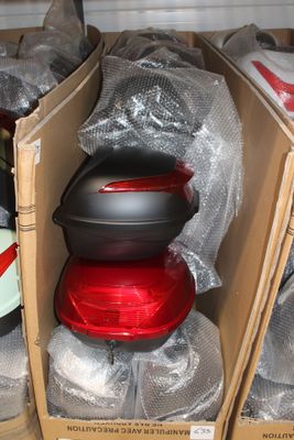 deux cartons contenant des casques de moto et un cyclomoteur