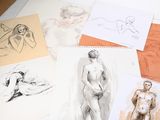 many drawings on a table that are on top of each other