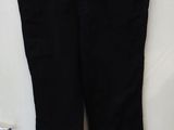 un pantalon noir accroché au mur, avec une ceinture orange