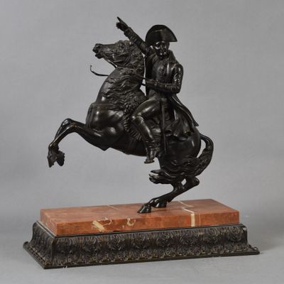 an antique bronze statue of a man on a horse on a marble base