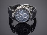an image of a wrist watch with a black strap on a reflective surface