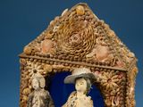a figurine of a man and a woman in a house made out of seashells