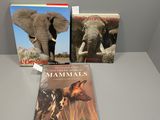 two books on a table with a picture of an elephant and a dog
