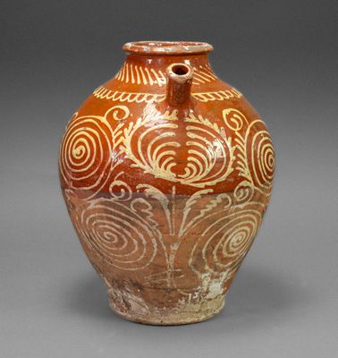 a brown and white vase with swirl designs on it