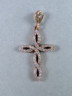 un gros plan d'un pendentif en forme de croix en diamant sur fond blanc