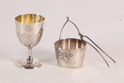a silver cup and a spoon sitting next to each other