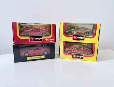 Deux petites voitures rouges sont dans des boîtes posées sur une surface blanche