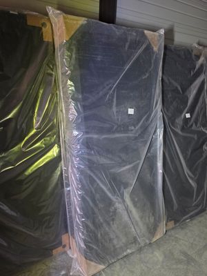 many pieces of furniture wrapped in plastic in a warehouse