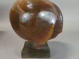 a brown and white sculpture of a bird on a stand