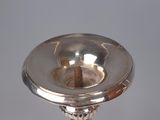 a silver candle holder on a table with a white background