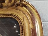 a gold frame with a clock in it on the wall