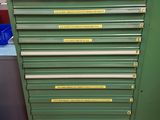 a green tool cabinet with many drawers on top of it