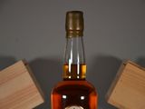 a bottle of whiskey sitting on a table next to a wooden box