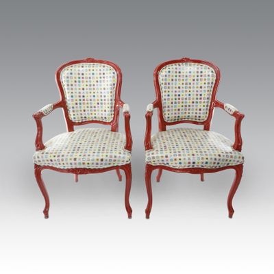 pair of red painted chairs with upholstered upholstered arms