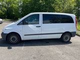a white van parked in a parking lot with trees in the background