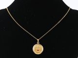 un collier plaqué or avec une petite pièce suspendue à une chaîne