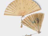 une image représentant une paire d'éventails chinois pliants posés sur une surface blanche
