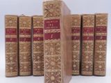 plusieurs vieux livres sont alignés sur une surface blanche