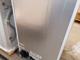 an image of a refrigerator in a room with a door open