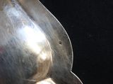 a silver spoon with a handle on a black surface