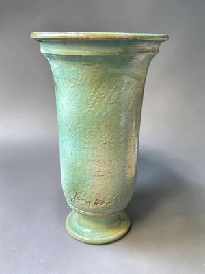 un vase vert posé sur une table