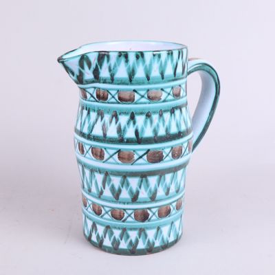 un pichet bleu orné d'un motif sur fond blanc