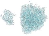 Des perles de verre bleues sont éparpillées en tas sur une surface blanche