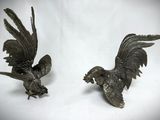 pair of antique bronze eagle figurines on white background
