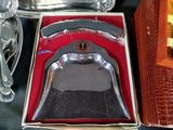 a silver bell sitting in a box on a table