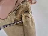 a close up of a doll wearing a dress with a zipper on it