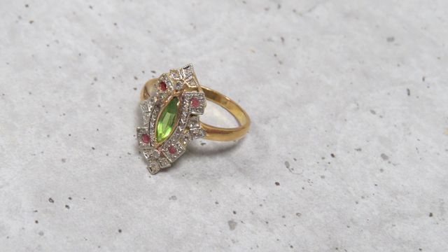 Bague en or 750‰ et platine, sertie d’une pierre verte de forme n...
