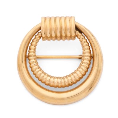 un gros plan sur une broche en or au motif circulaire