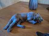 a statue of a dog that is laying on a table