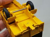 a person holding a yellow toy truck in their hand