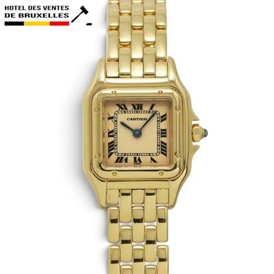 a close up of a gold wrist watch with roman numerals