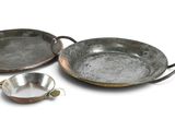 three metal pans sitting on top of each other on a white surface