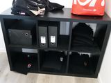 a black bookcase with several bins on top of it