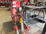 a red machine that is sitting on a table in a warehouse