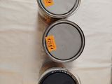 three cans of paint sitting on top of a table next to each other