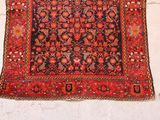 rug hanging on a wall in front of a white brick wall