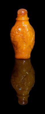 un vase jaune posé sur une surface réfléchissante