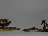 three bronze figurines of ducks sitting on top of each other